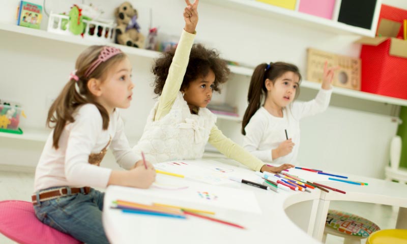 Children raising their hands to answer questions