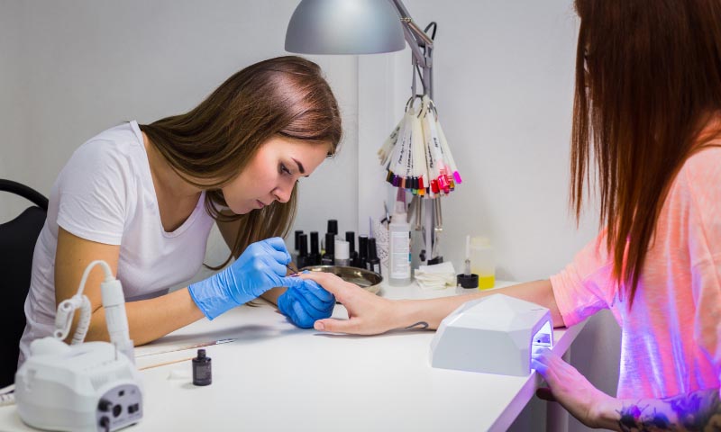 A student tending to a customers nails