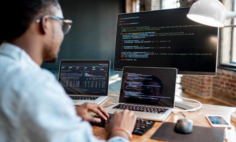 A man using a multi monitor computer setup